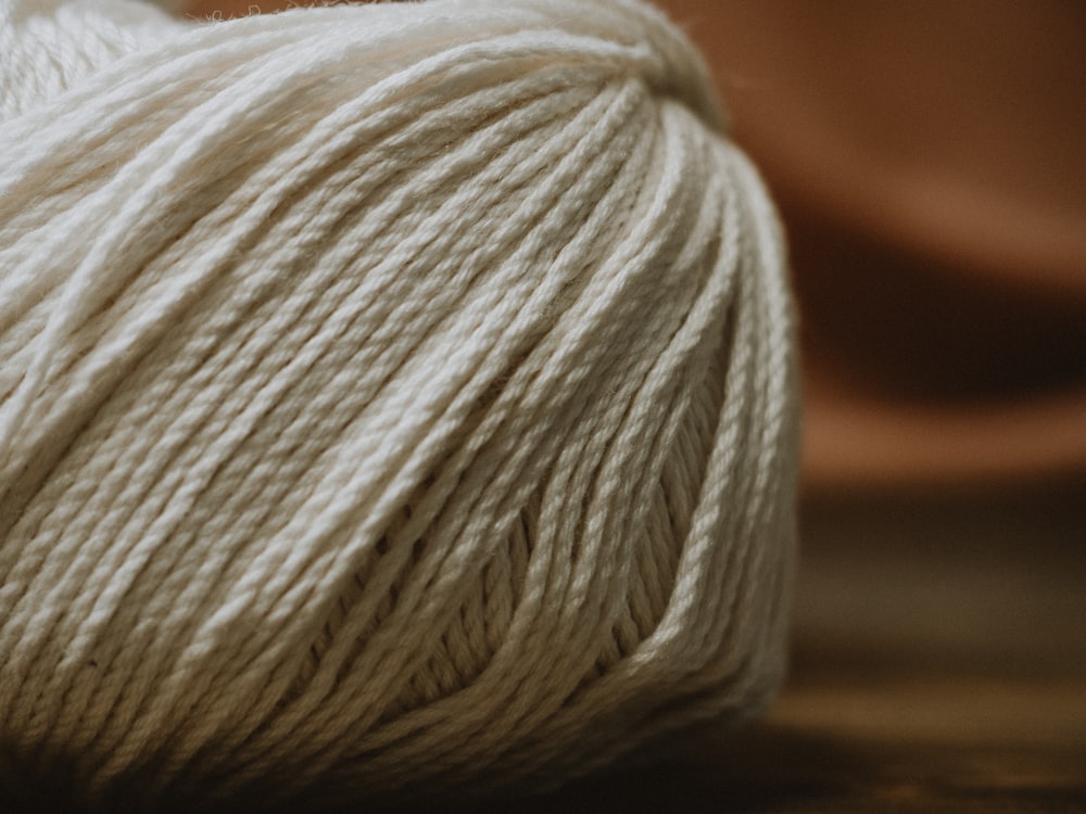 white yarn on brown wooden table