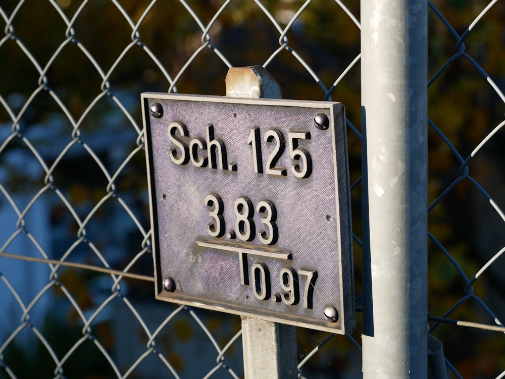 a close up of a sign on a fence