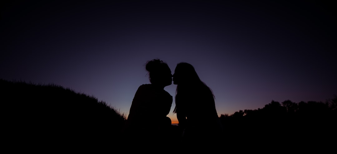 silhouette of man and woman kissing during sunset