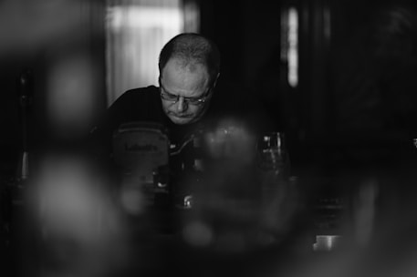Black and white photo of a focused professional analyzing complex data on a transparent screen.