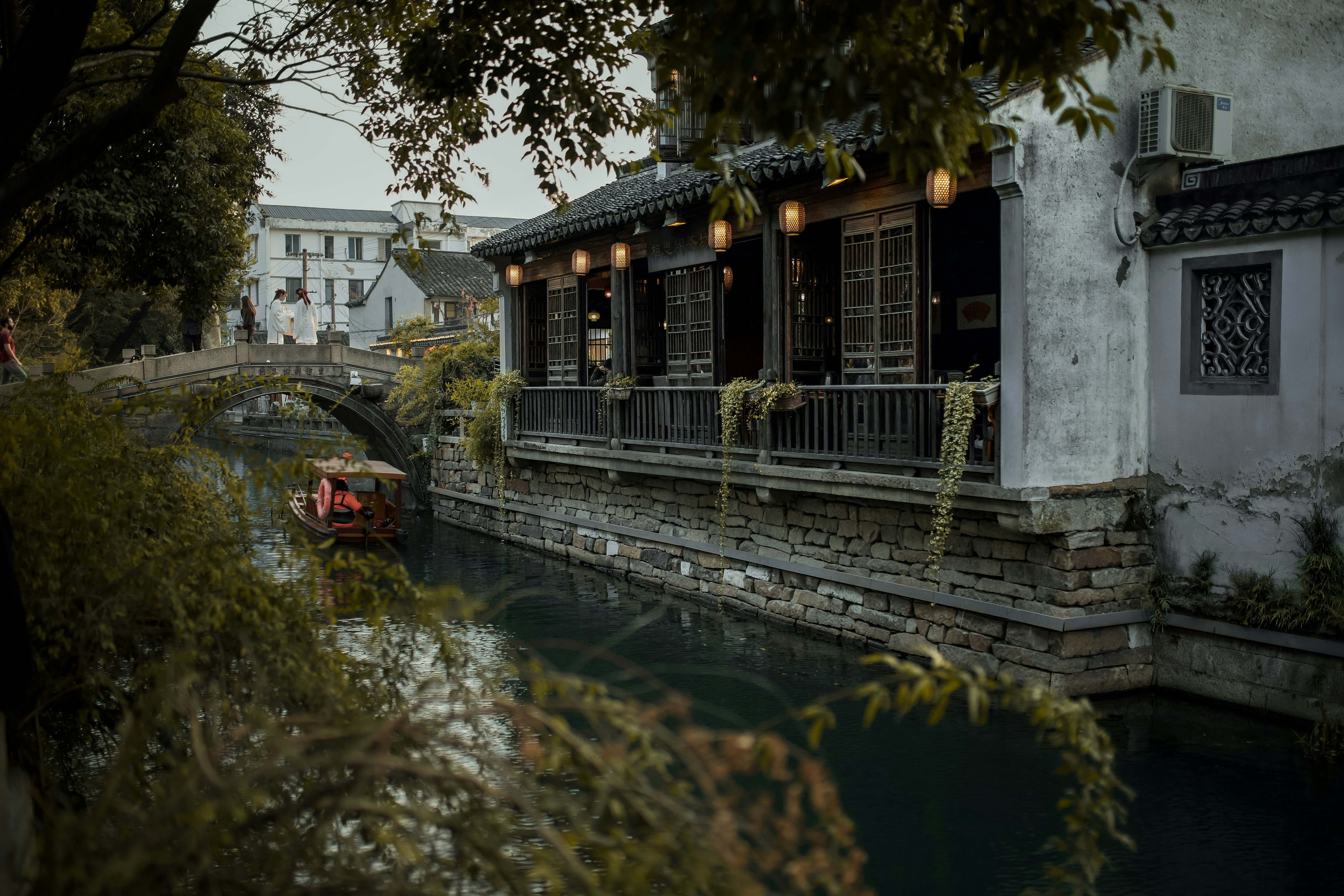 white and brown wooden house near river during daytime