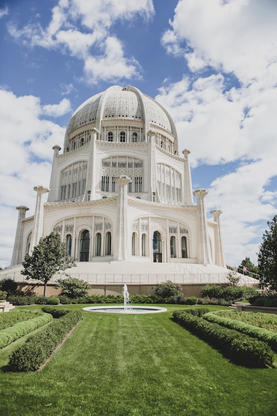 white concrete building under blue sky during daytime in Baha'i House of Worship United States