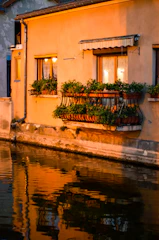 A softly lit Provençal villa at dusk, showcasing warm golden lights highlighting its elegant architecture.
