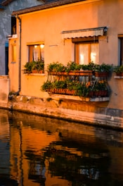 Exterior shot of the hostel building at sunset with warm lights glowing.