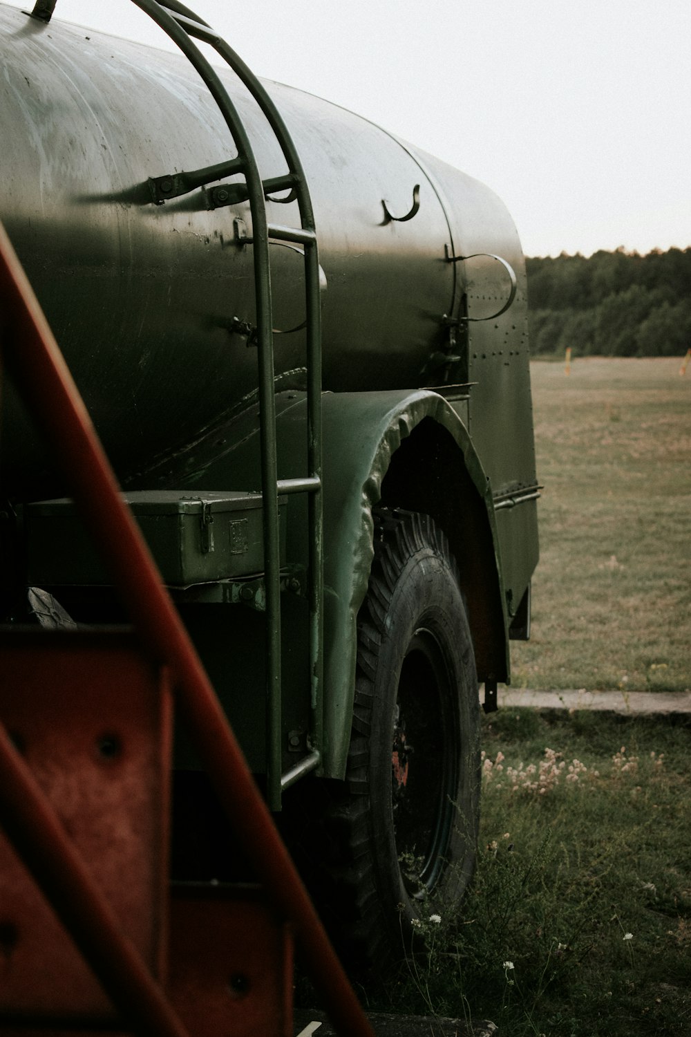 green and red truck on green grass field during daytime