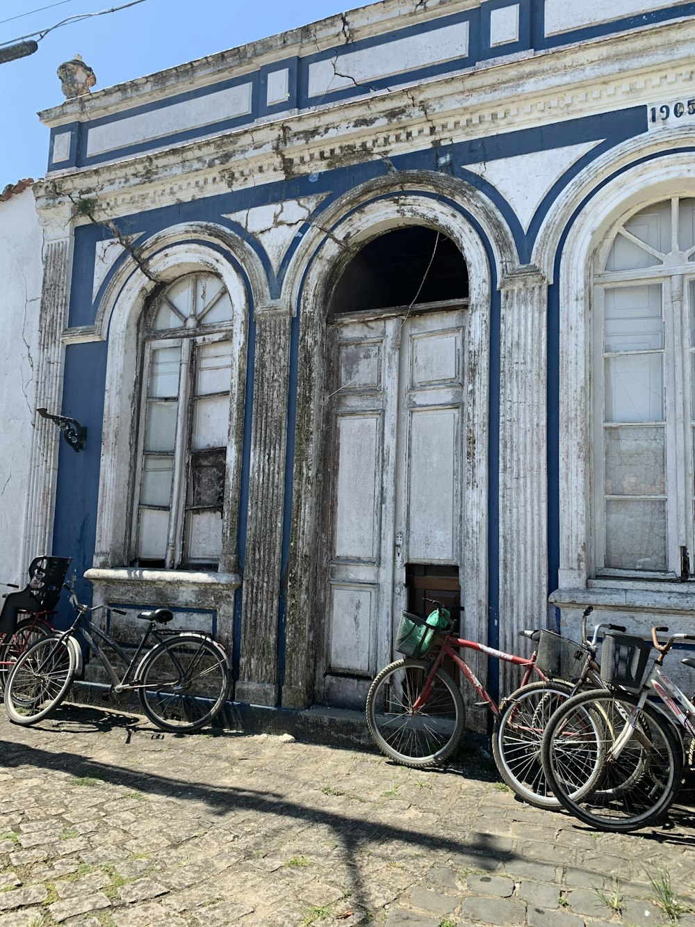 파란색 콘크리트 건물 앞에 주차된 자전거
