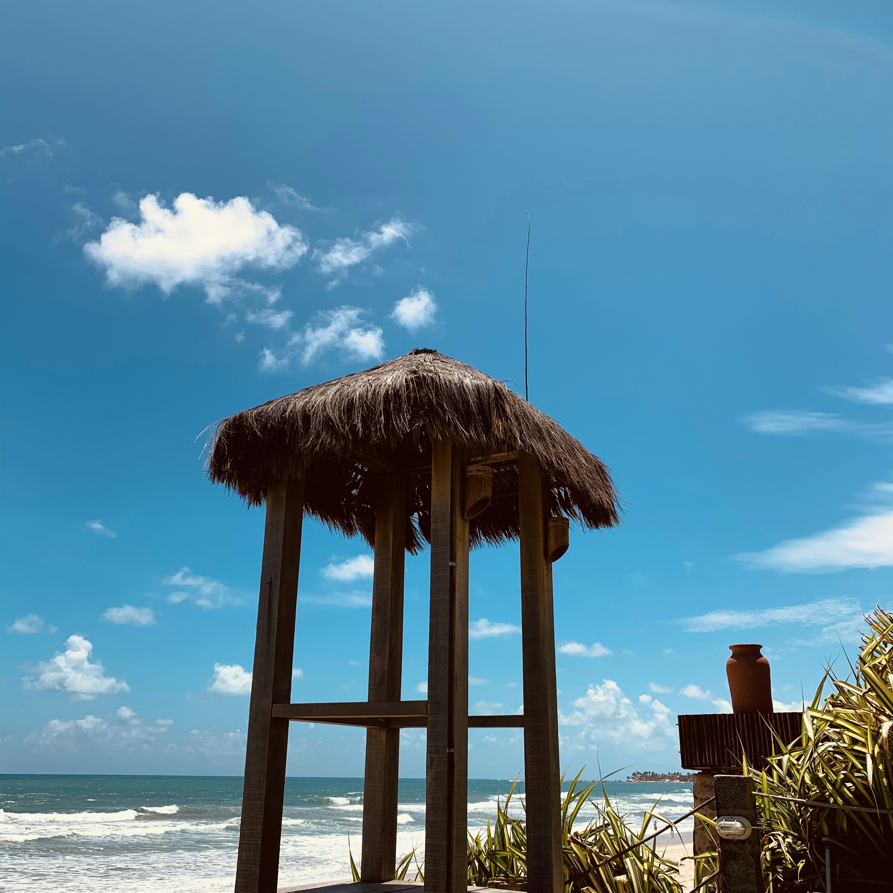 brown wooden beach house near sea under blue sky during daytime