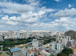 city buildings under blue and white sunny cloudy sky during daytime