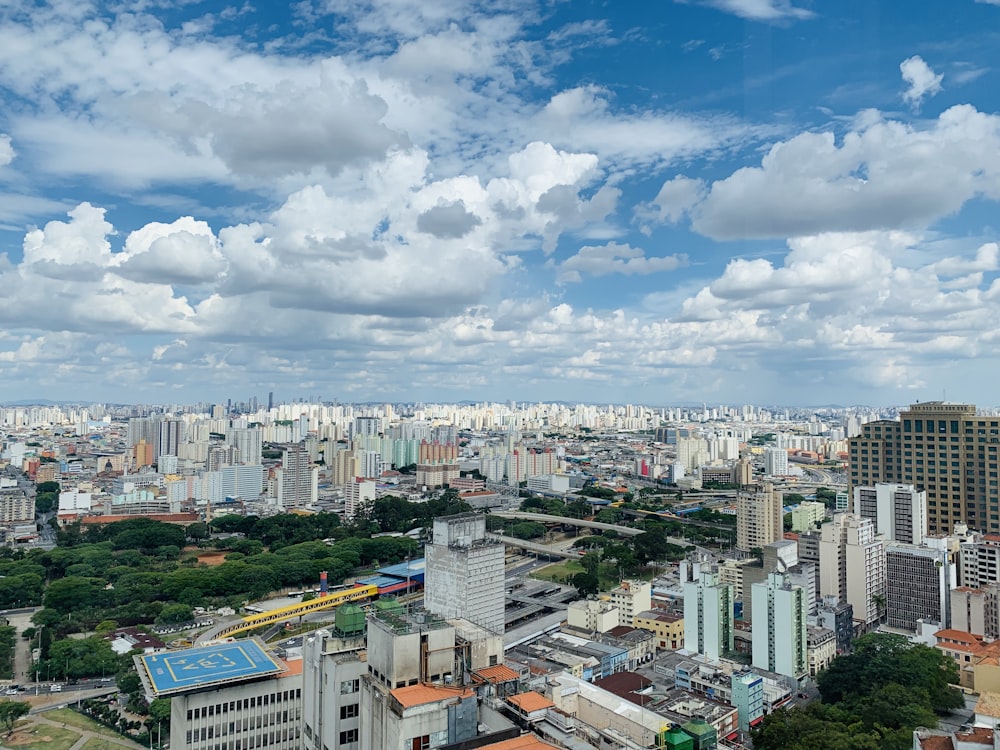 city buildings under blue and white sunny cloudy sky during daytime