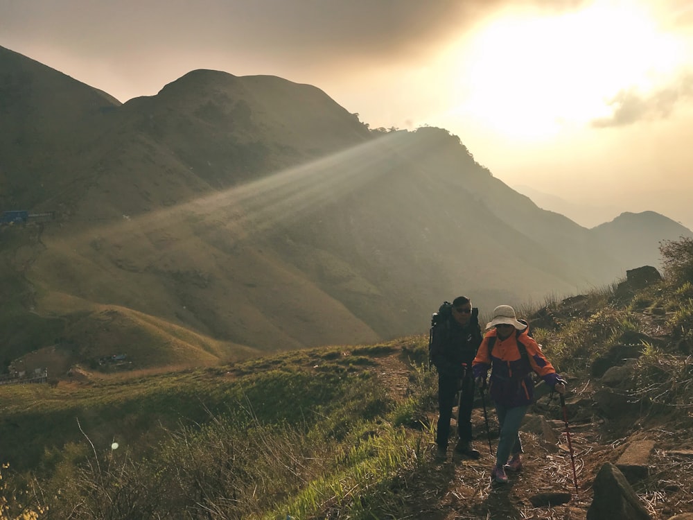 2 people hiking on mountain during daytime