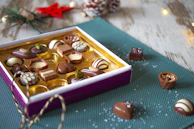 A joyful group of friends and family sharing chocolates, their faces lit with happiness.
