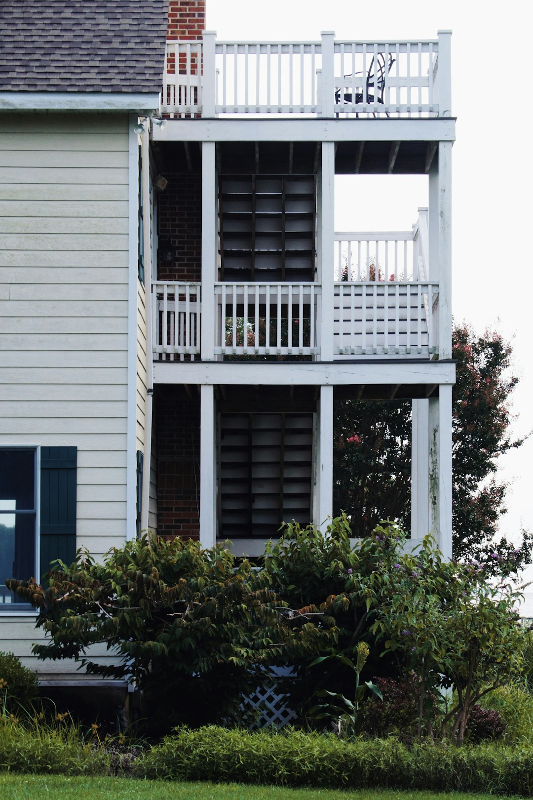 white wooden house with green plants