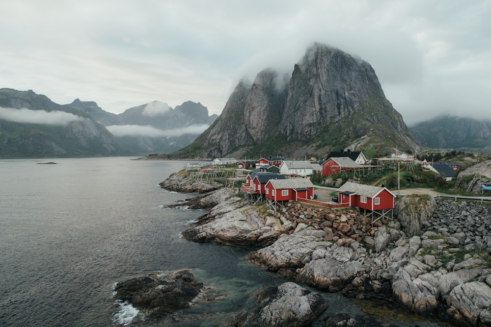 houses on rocky mountain beside sea during daytime