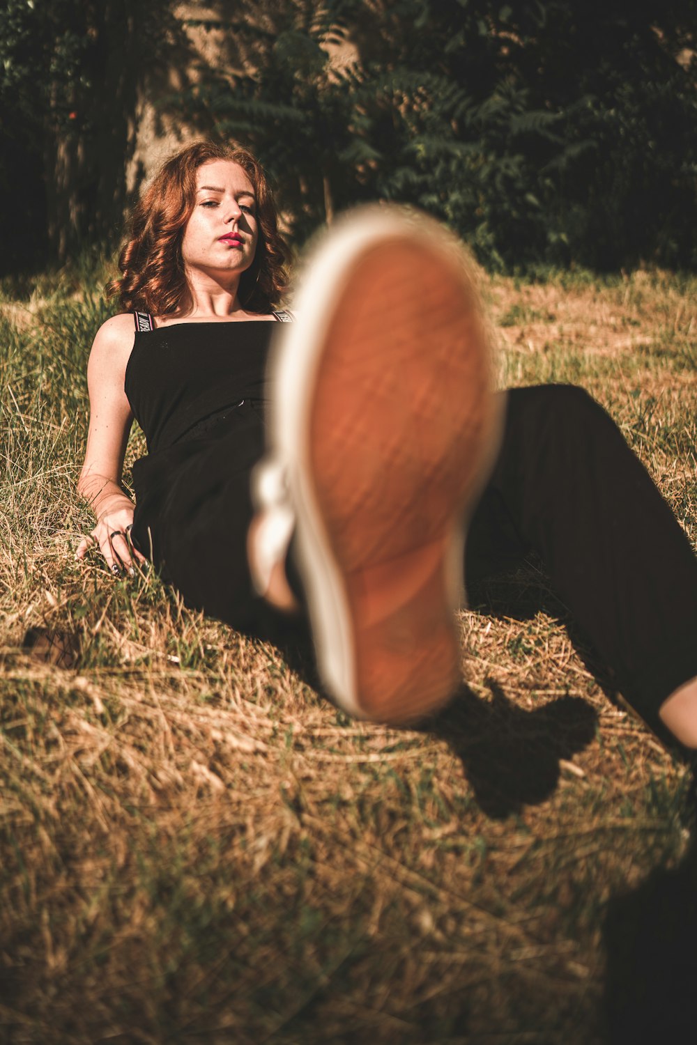 woman in black tank top and black pants sitting on brown wooden chair