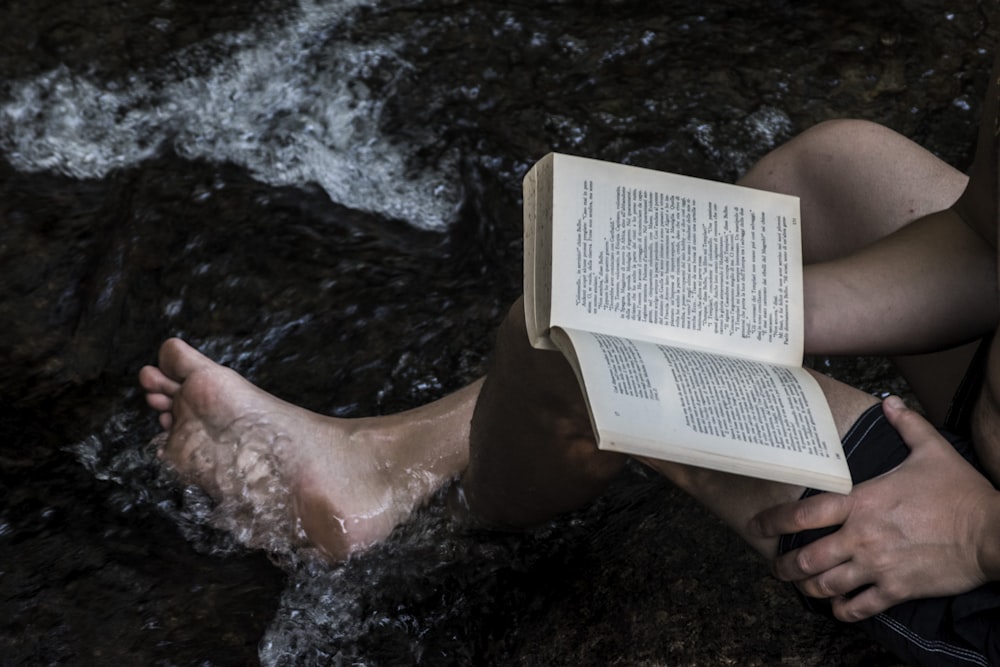 person holding white box on water