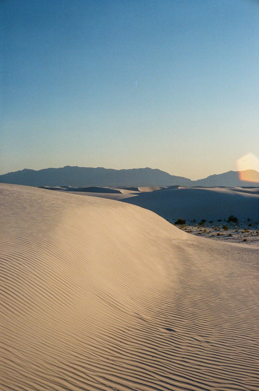 campo de areia marrom perto da montanha durante o dia