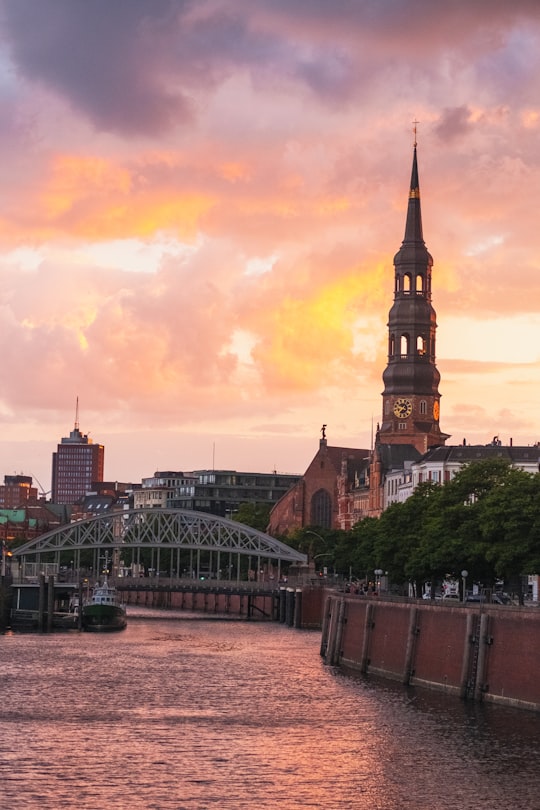 brown and black concrete building under orange sky in Speicherstadt Germany