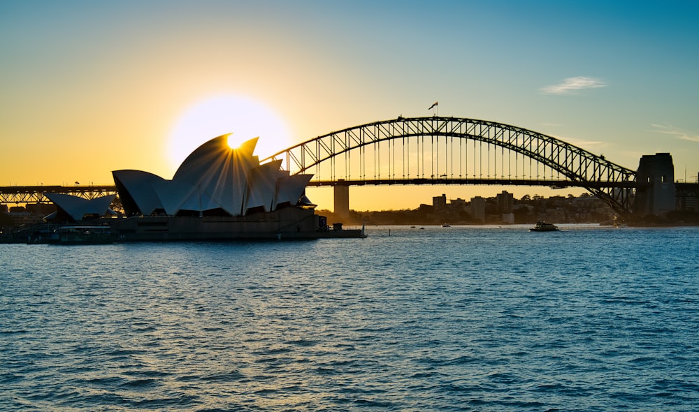 silhouette of bridge over body of water during daytime