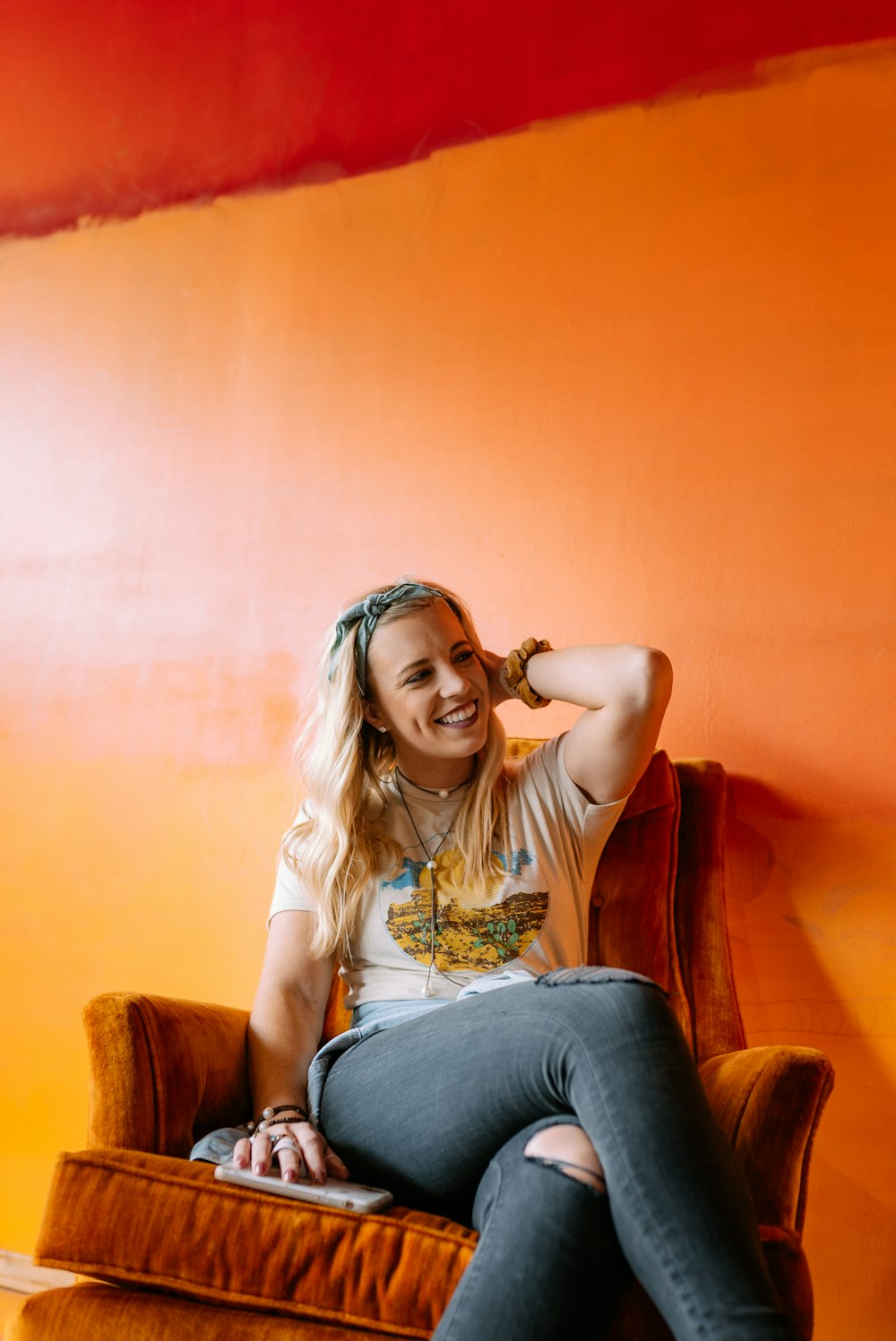 woman in white shirt and blue denim jeans sitting on brown sofa