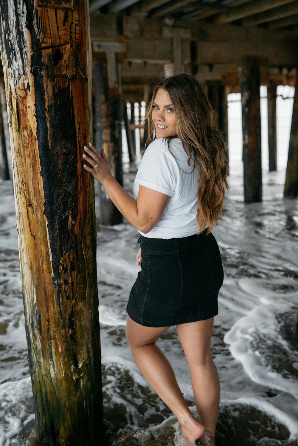 woman in white t-shirt and black skirt standing on water