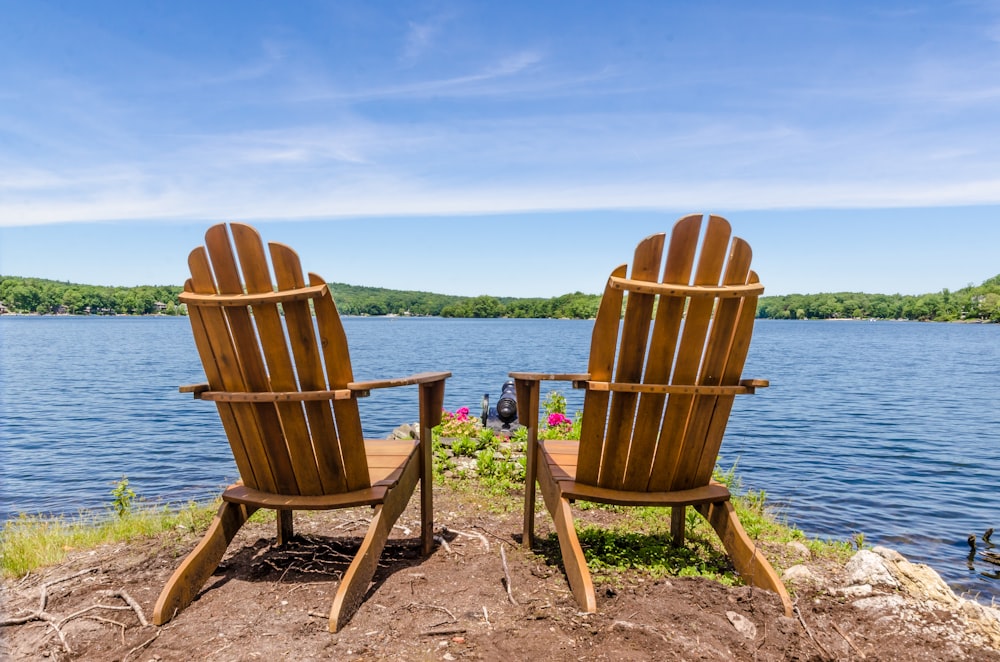 two brown wooden armchairs on beach shore during daytime