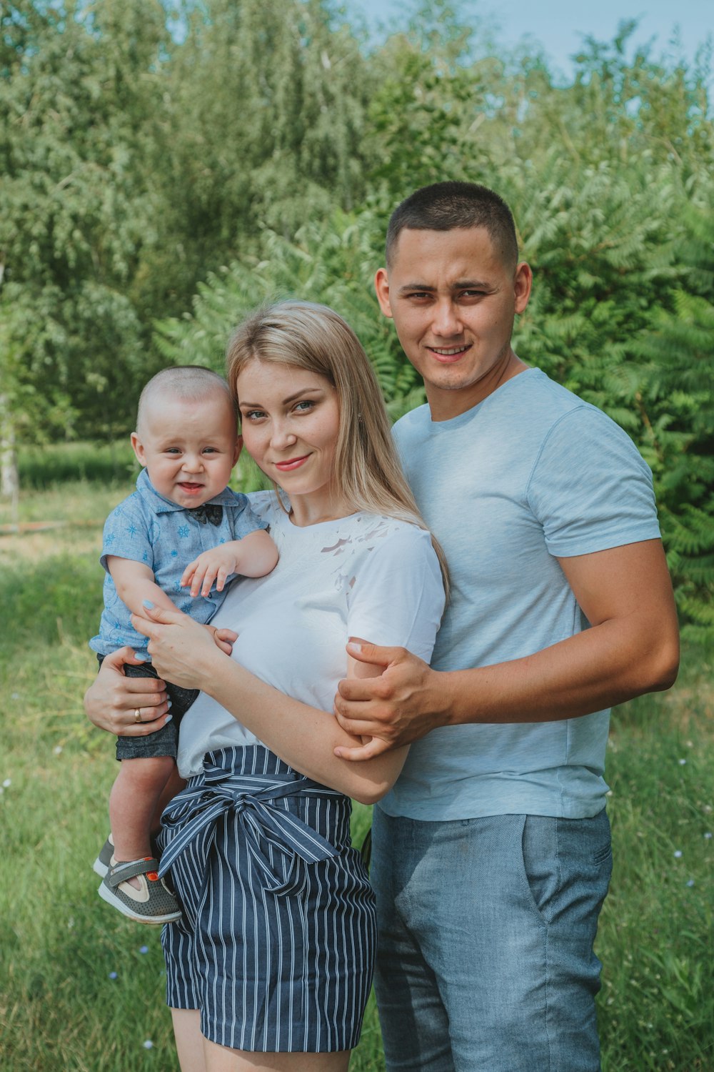 man in blue crew neck t-shirt carrying girl in white and blue stripe dress