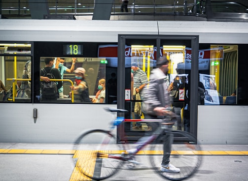 man in black jacket riding bicycle on road during daytime