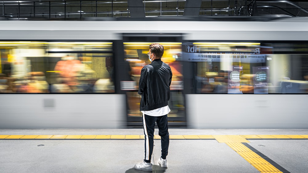 駅に立つ黒いジャケットの男