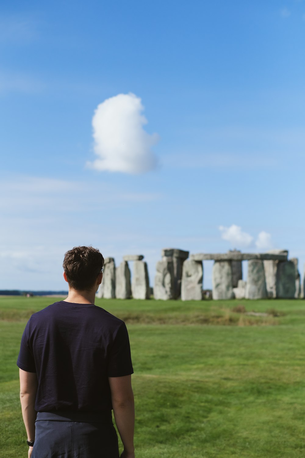 man in black crew neck t-shirt standing on green grass field during daytime