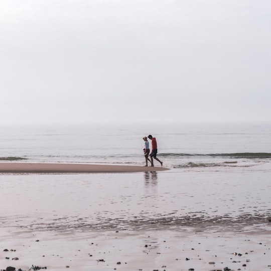 woman in black shirt walking on beach during daytime in Wissant France