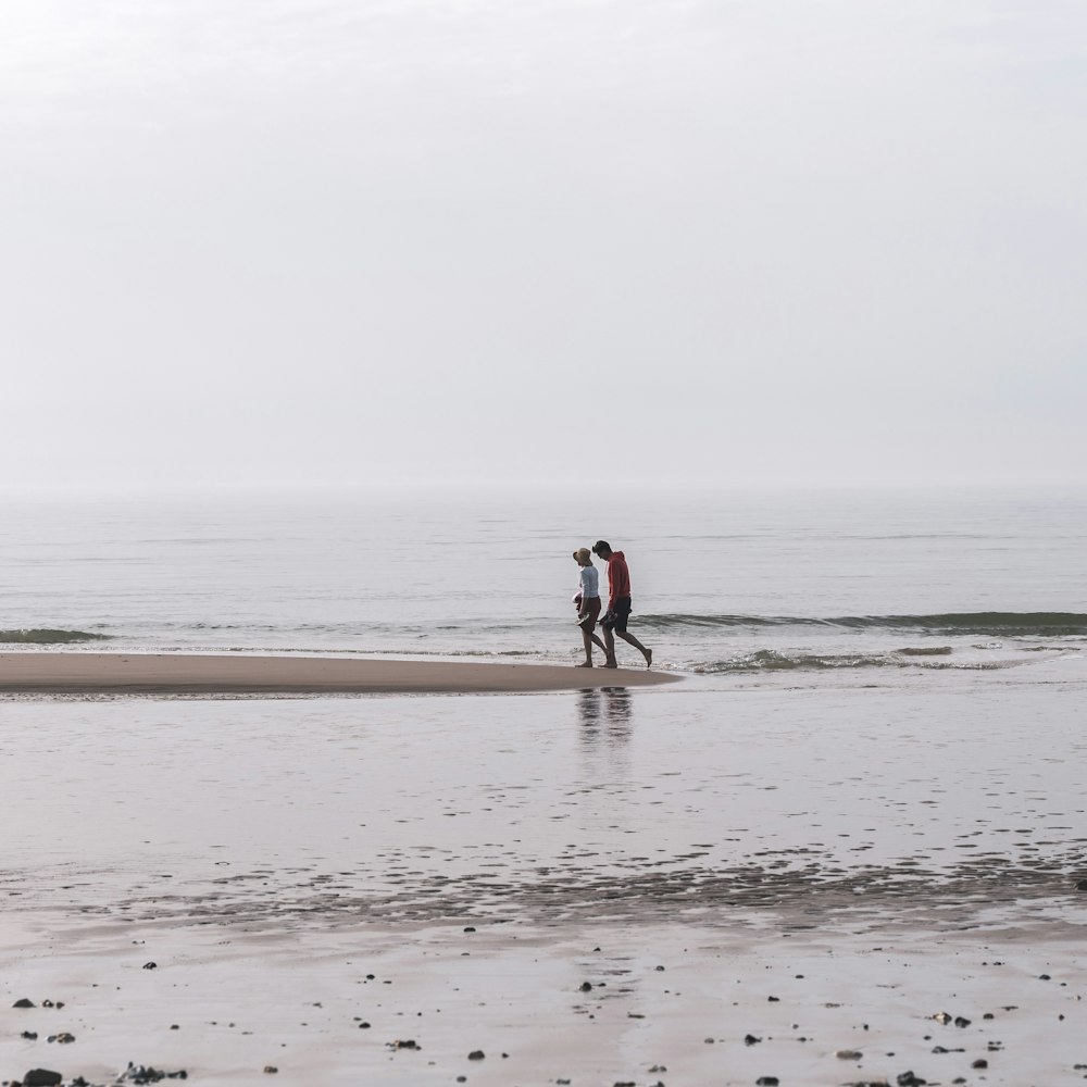 woman in black shirt walking on beach during daytime