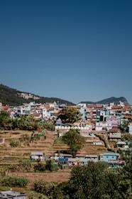 Colorful image of a traditional Indonesian village surrounded by lush green hills under a clear sky.