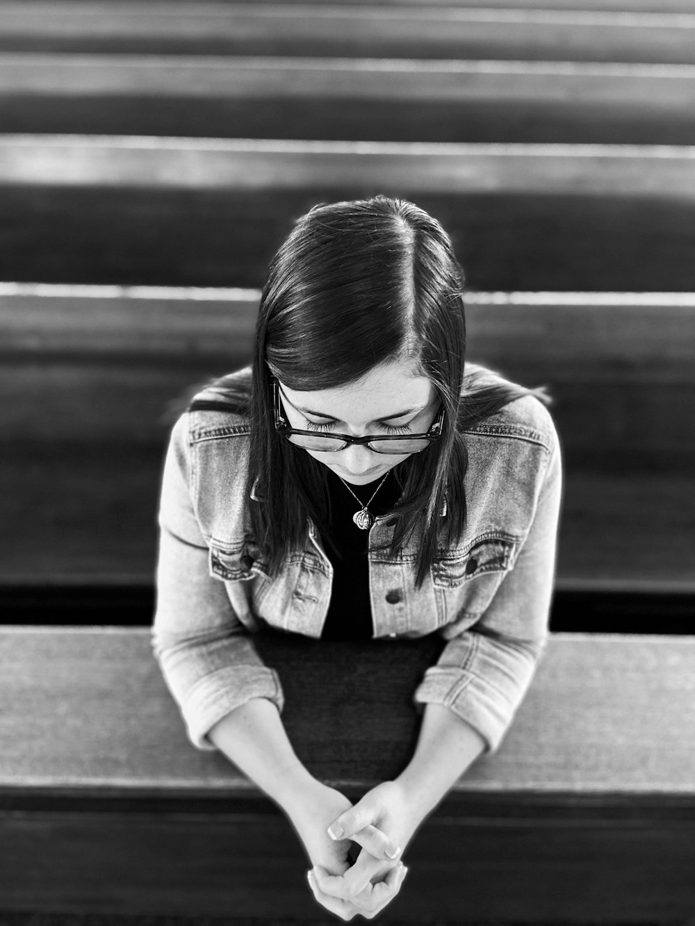 grayscale photo of woman in denim jacket and eyeglasses