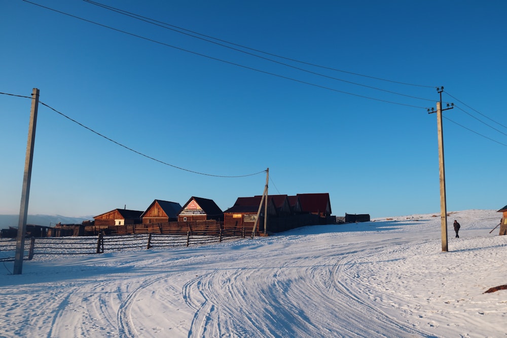 brown wooden house on snow covered ground under blue sky during daytime