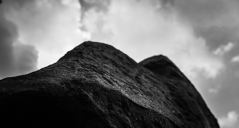 grayscale photo of mountain under cloudy sky