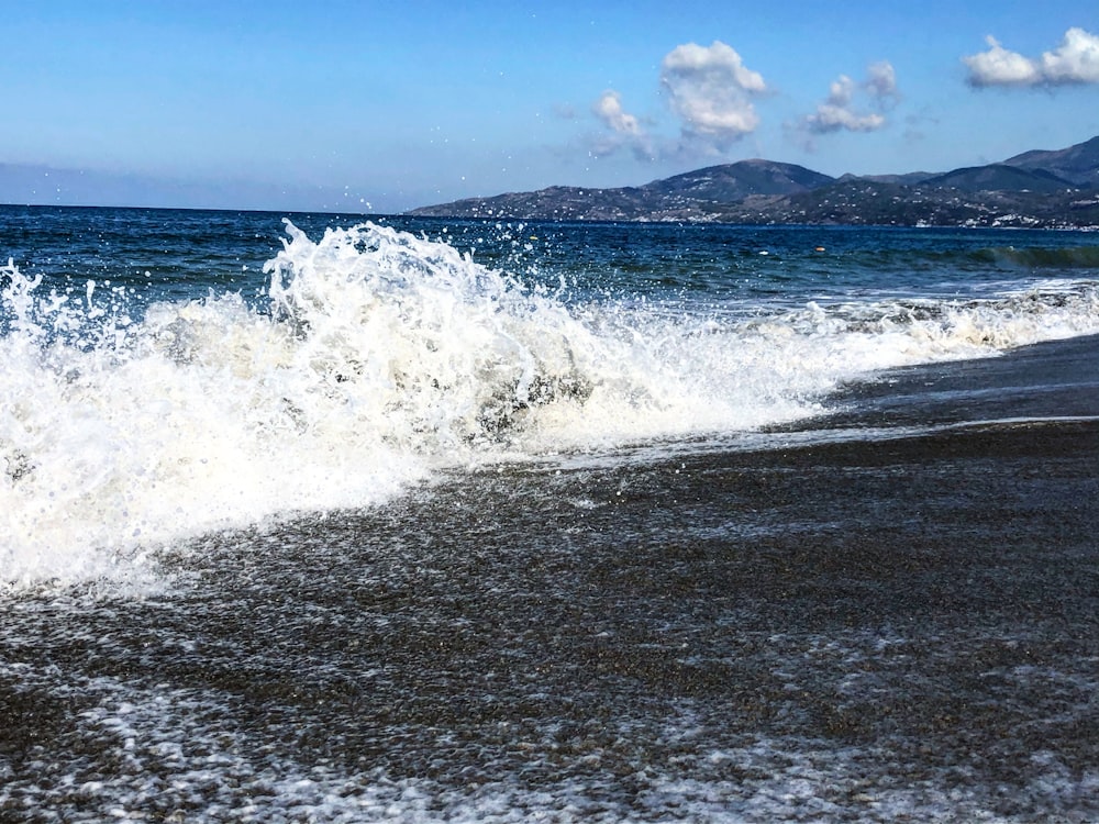 ocean waves crashing on shore during daytime