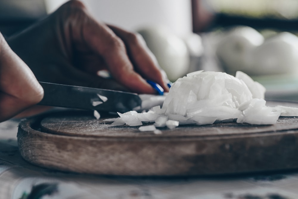 person holding blue and white powder on brown wooden tray