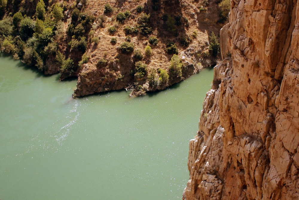 brown rock formation beside body of water during daytime