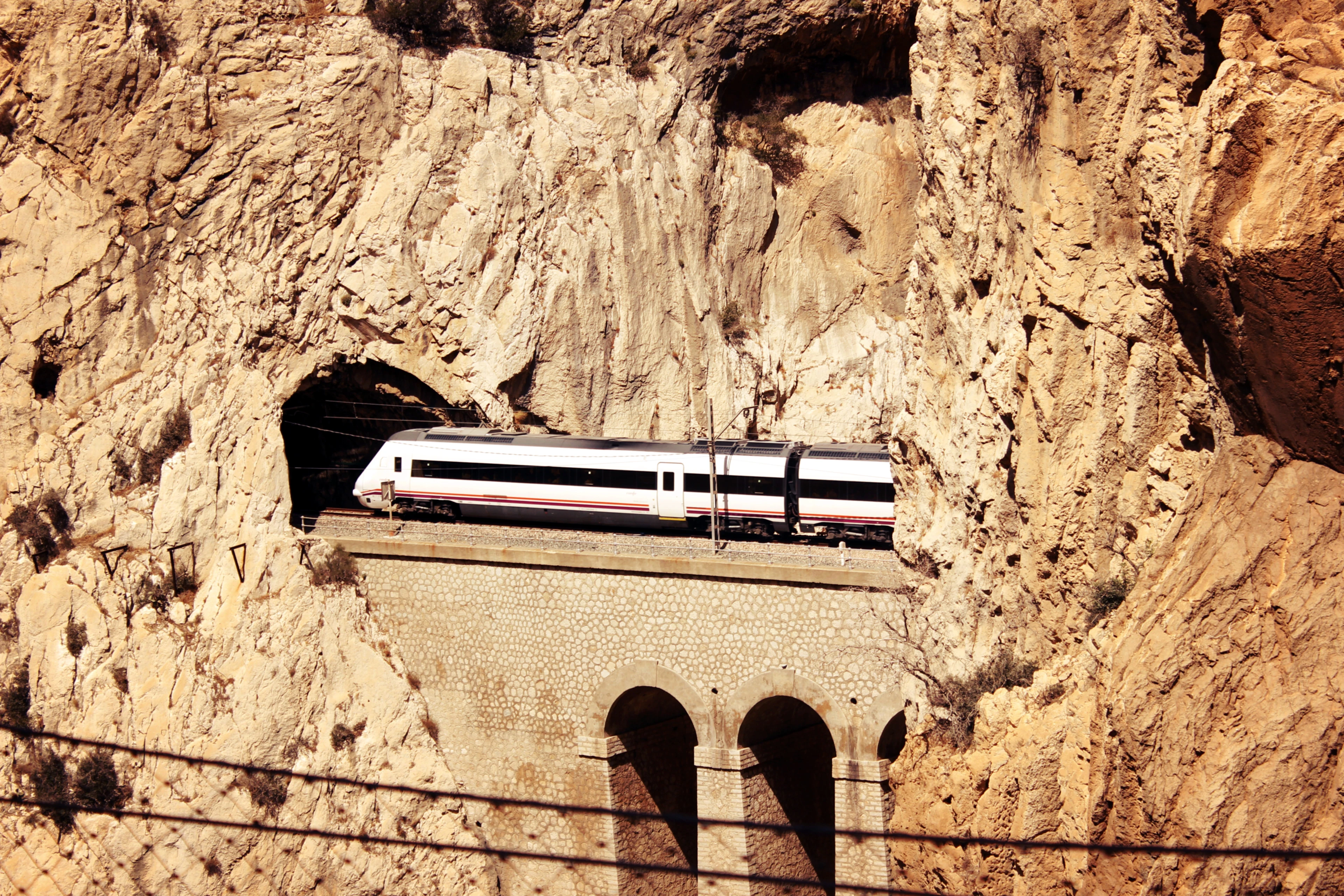 A train crosses a stone viaduct through the dramatic El Chorro gorge near Málaga.