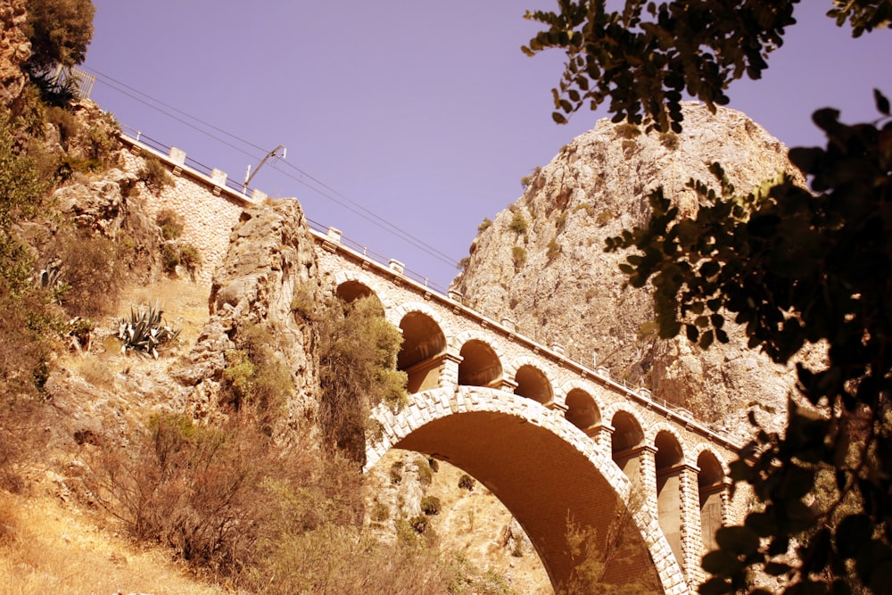 ponte de concreto marrom sob o céu azul durante o dia