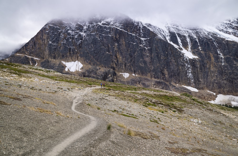 Montaña rocosa gris bajo el cielo blanco durante el día