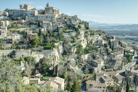 gray concrete building on top of mountain during daytime in Gordes France