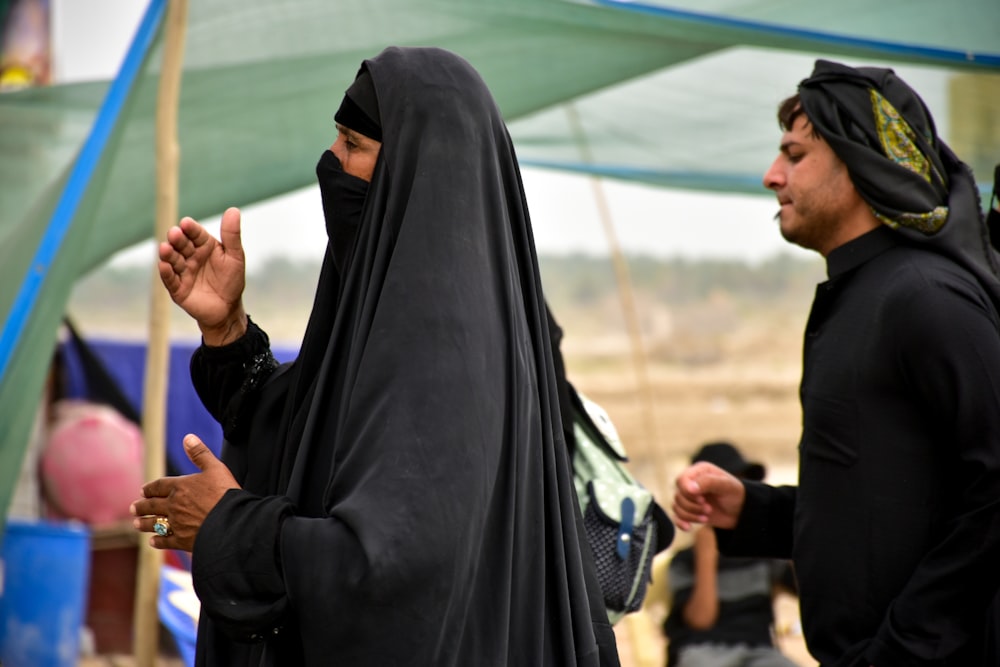 woman in black hijab standing near people during daytime