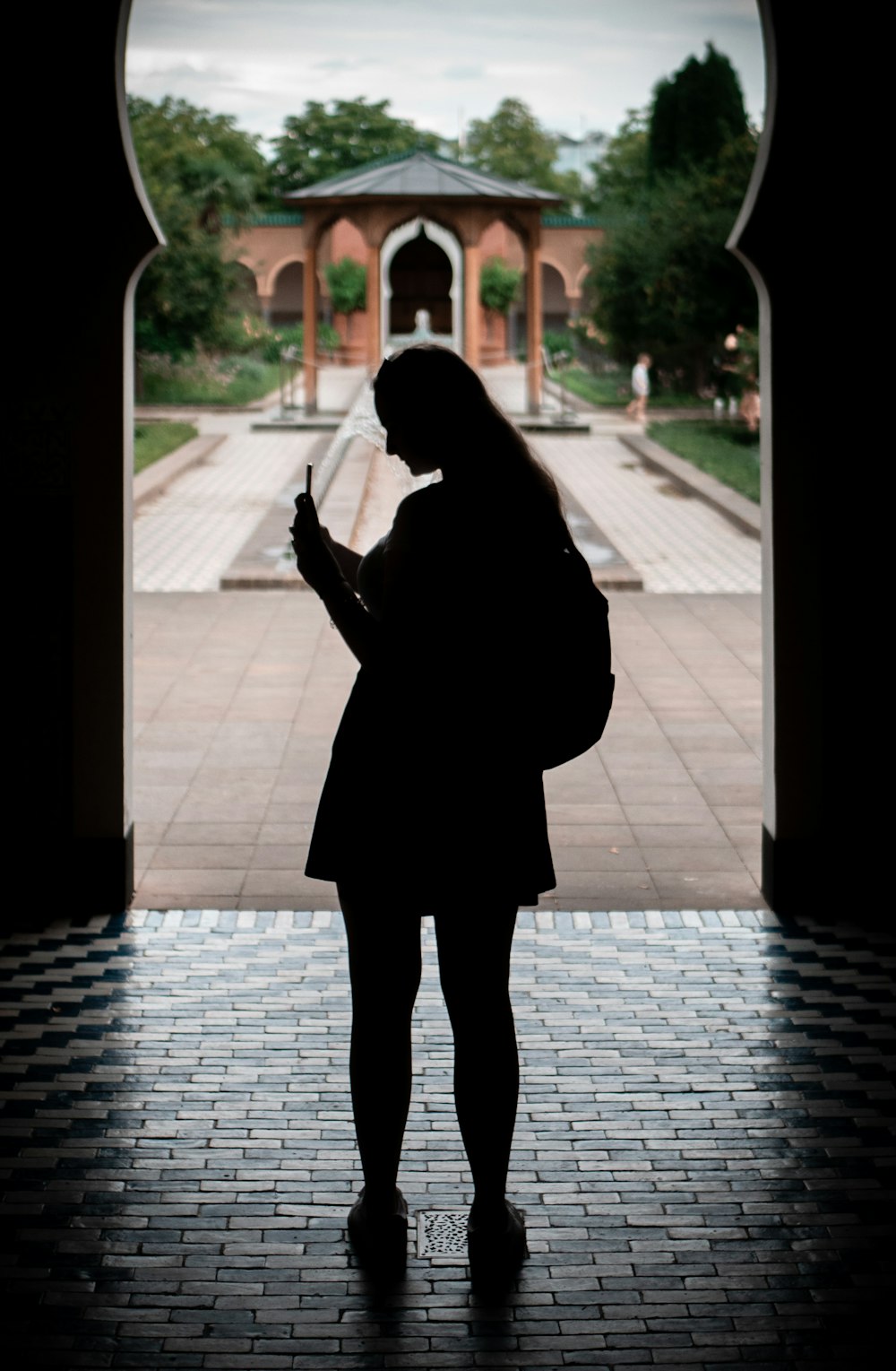 person in black coat standing on gray concrete floor during daytime