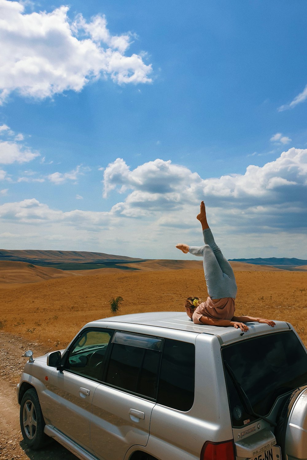 white van on brown field under white clouds and blue sky during daytime