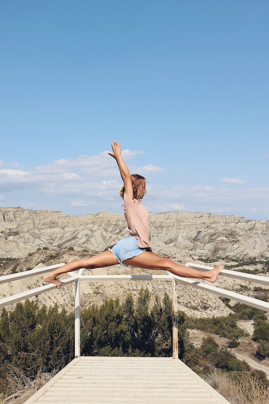 woman in white bikini sitting on white metal bar during daytime in Vashlovani Georgia