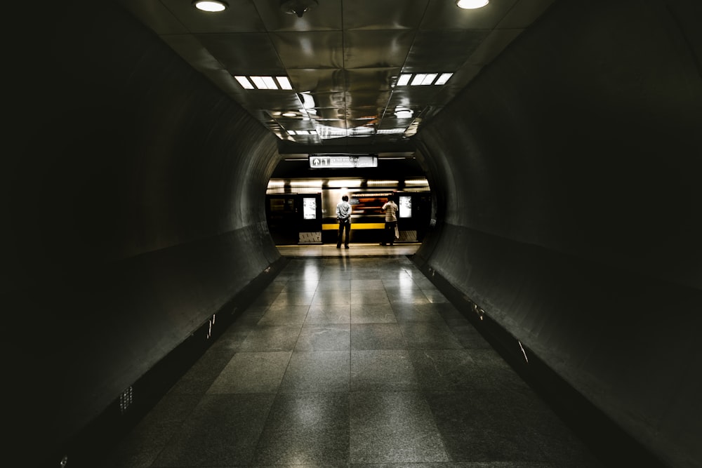 white and black hallway with lights turned on in the middle