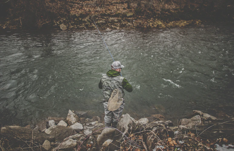 fly fisherman silhouette against blue sky