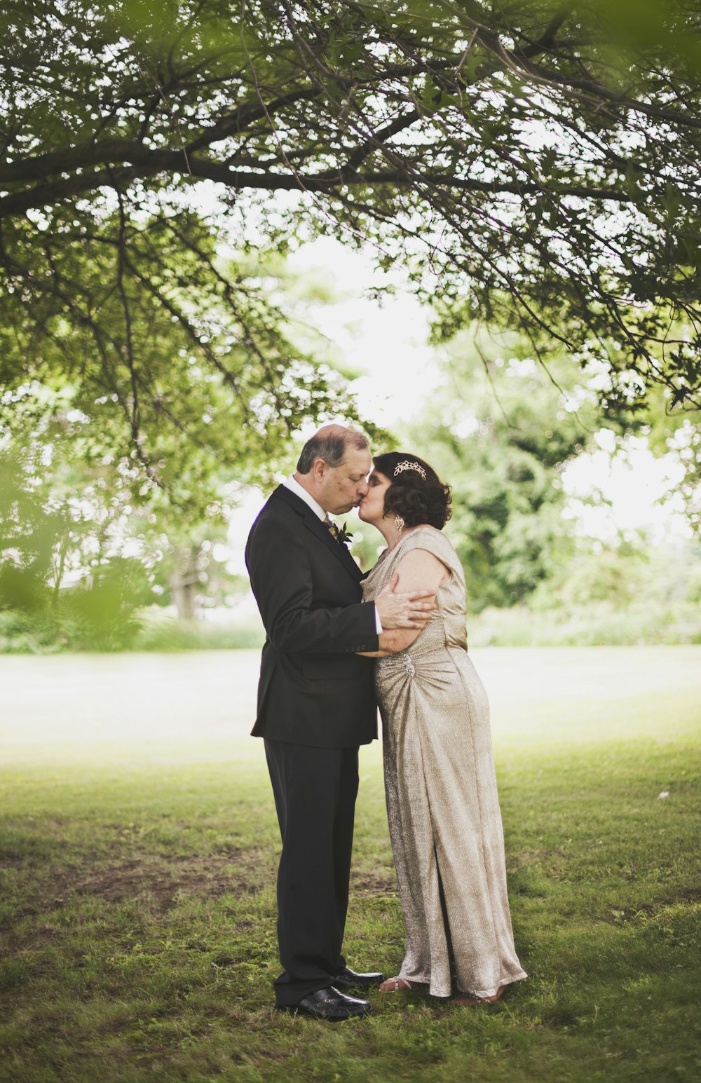 Mann und Frau küssen sich tagsüber auf grünem Rasen