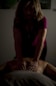 A person is giving a massage in a dimly lit room. The focus is on the hands applying pressure on the back of the individual lying down. The atmosphere appears calm and therapeutic.